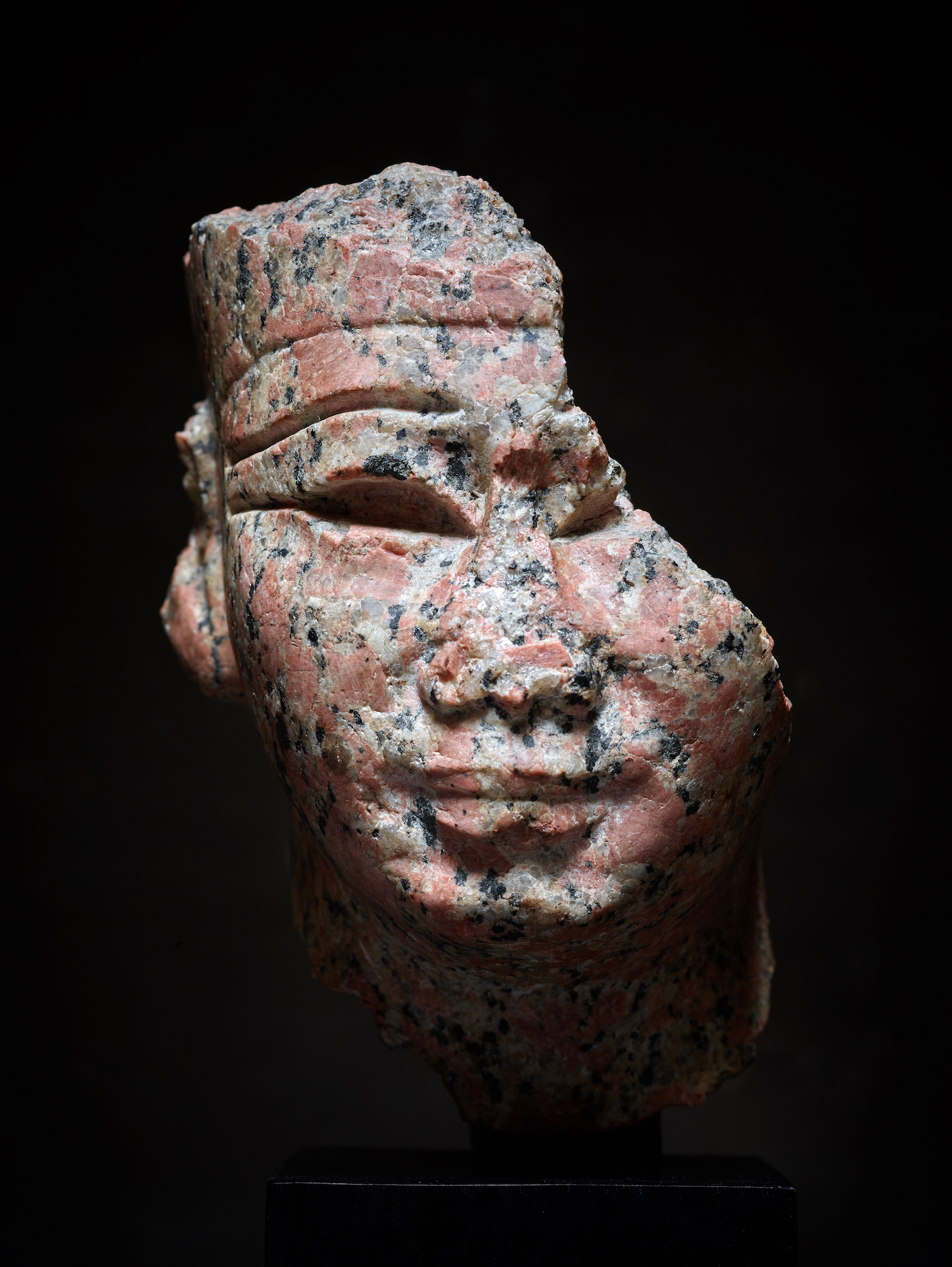 "Head of a god or a royal figure" in red granite at the Axel Vervoortdt booth at BRAFA 2023